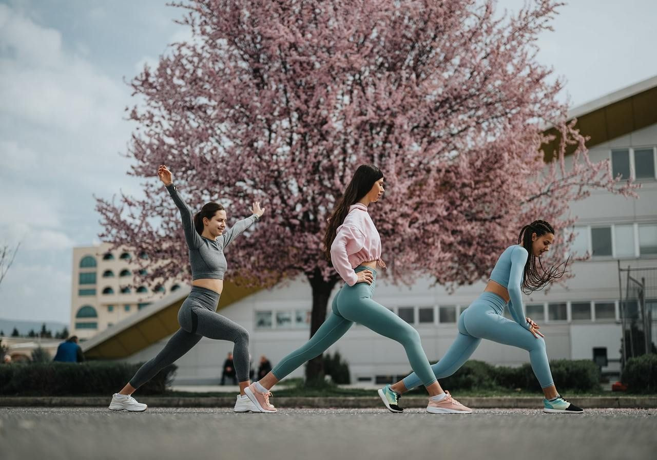 A group of three women wearing athleisure and exercising.